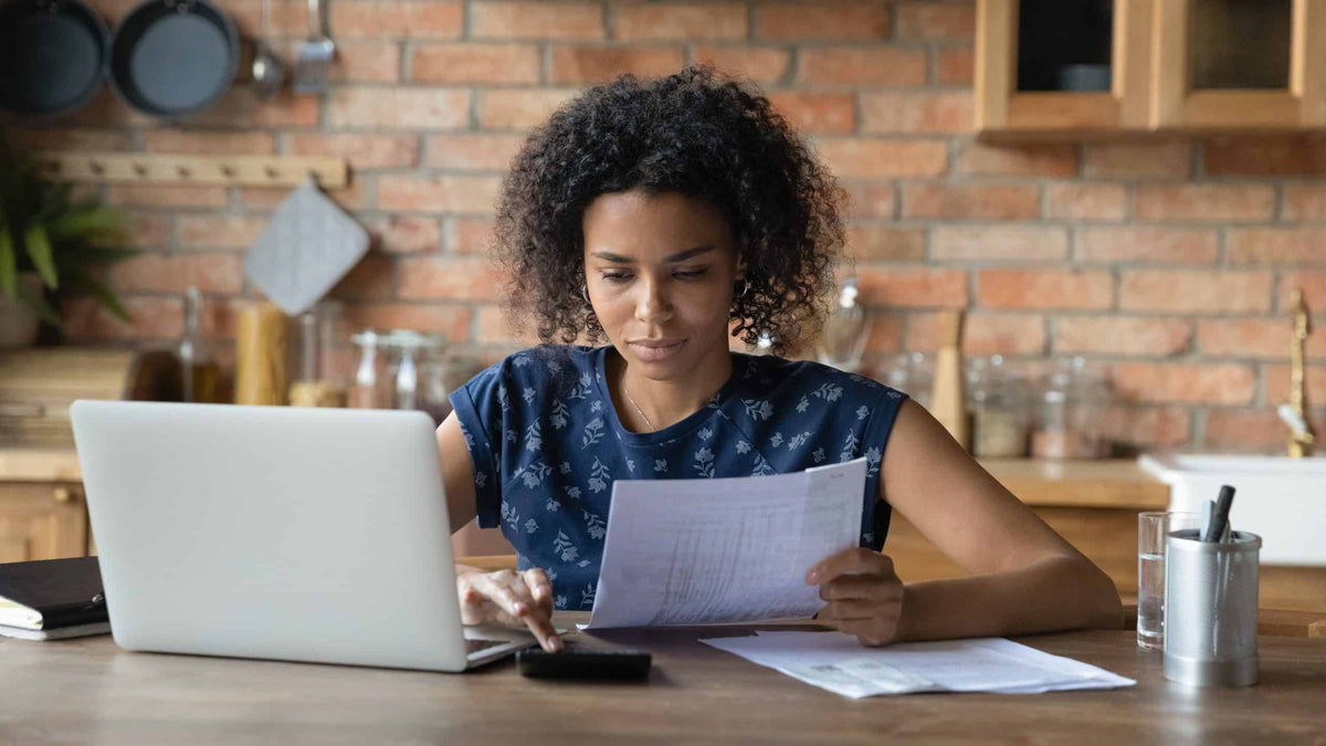 Millennial-Frau verwaltet Haushaltsfinanzen in der Küche